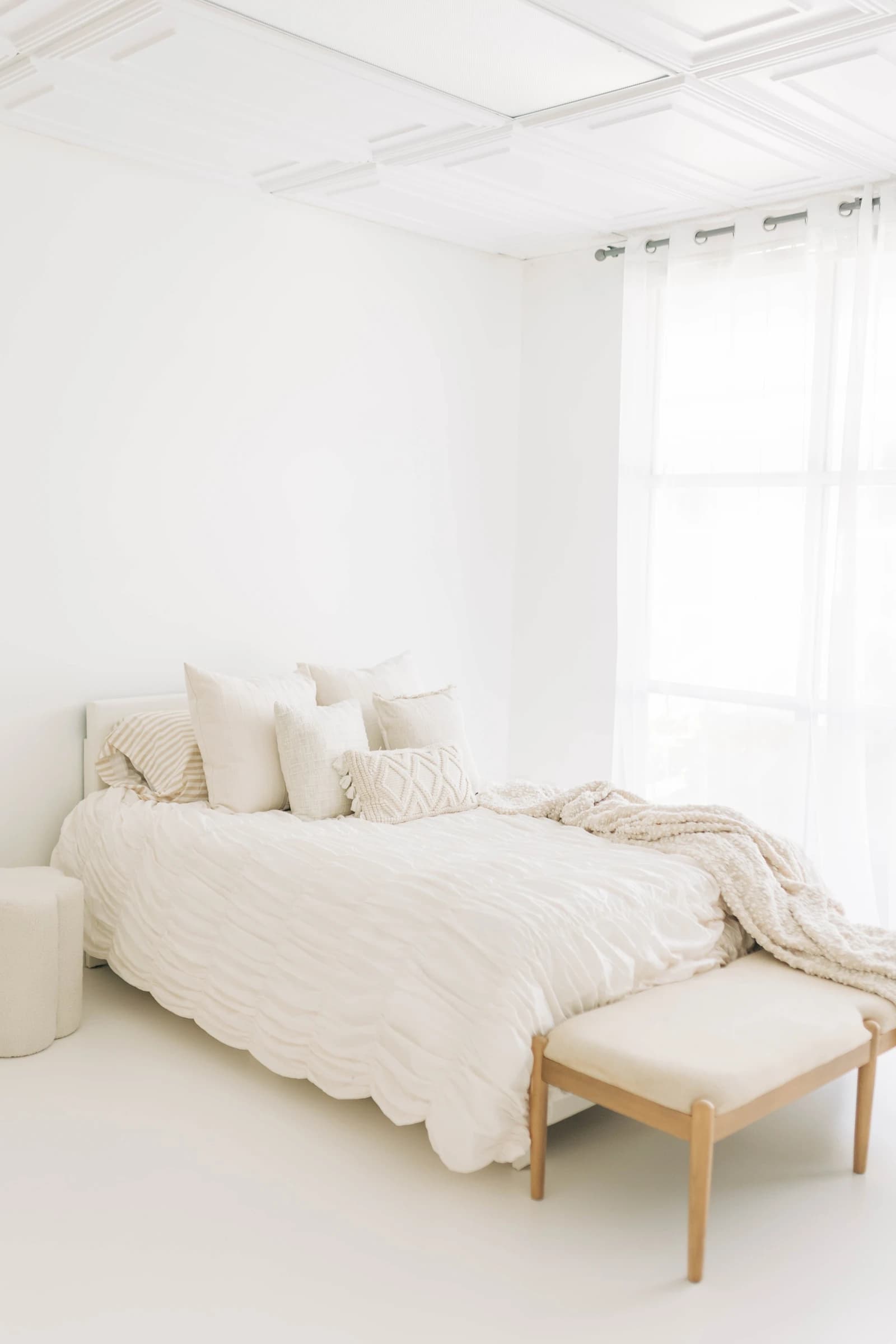A bright, photo-ready styled bed by the window
