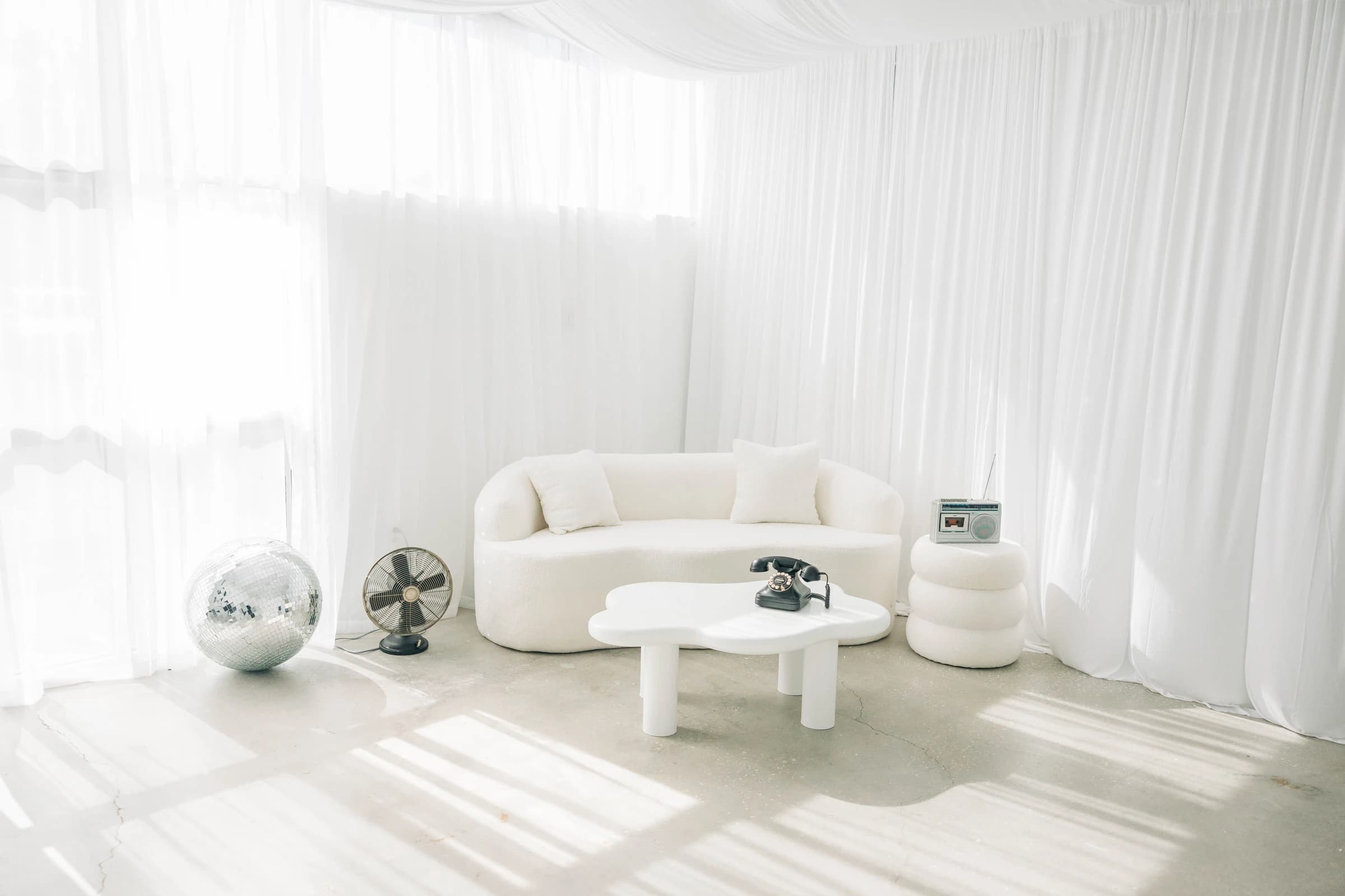 Studio B: morning light washing over concrete floors and a curved white sofa